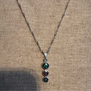 Necklace is a three-stone vertical pendant (often called a "trilogy" pendant)